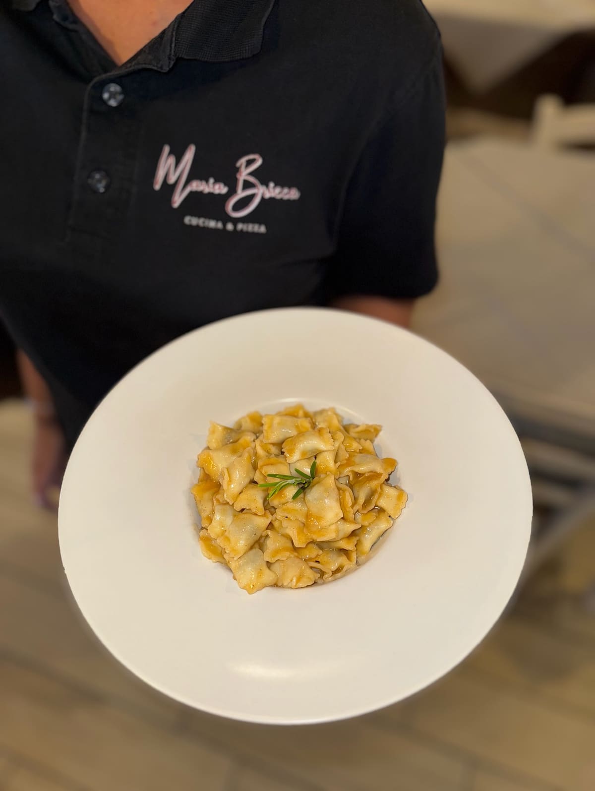Agnolotti serviti dal personale in un piatto fondo