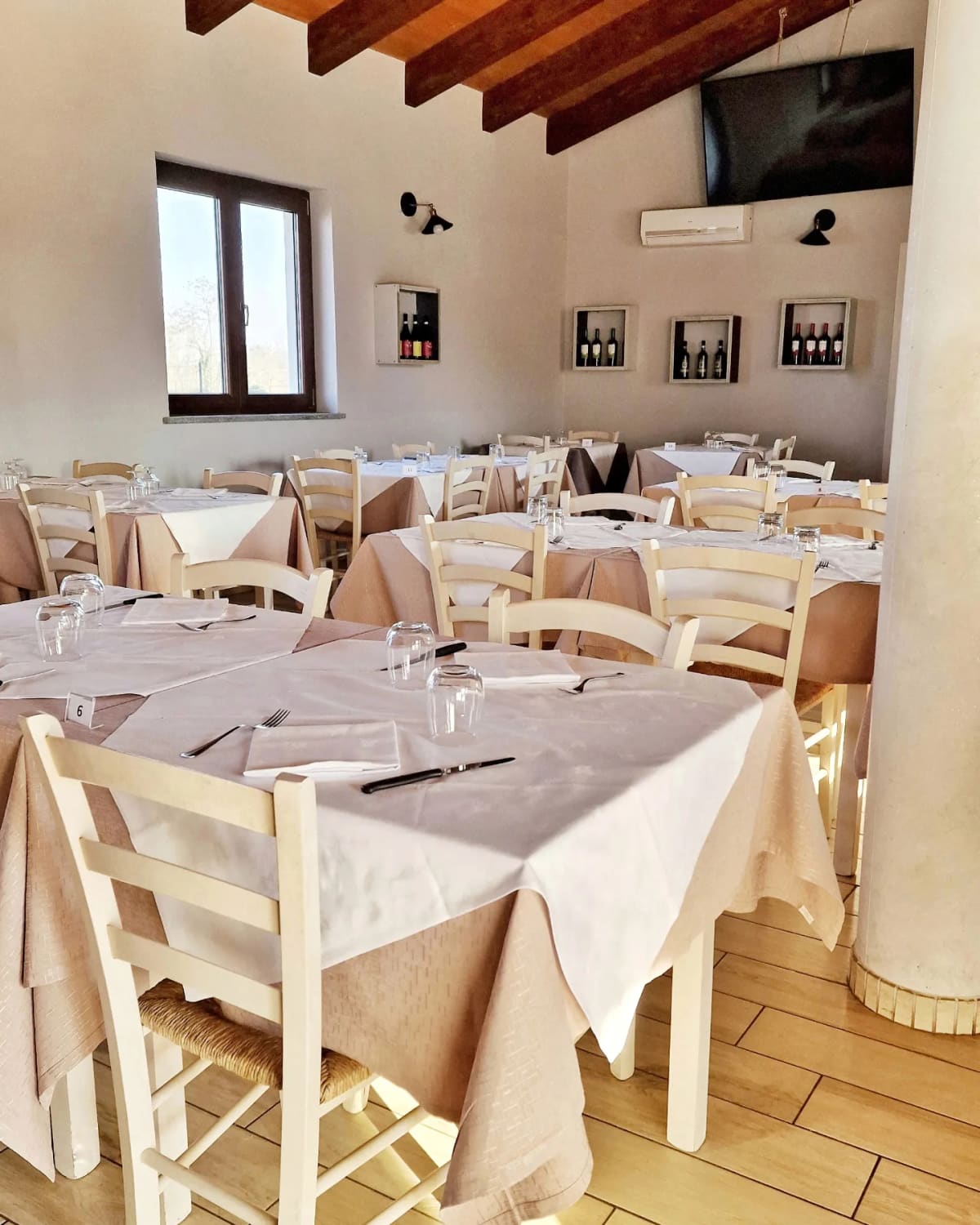 La sala interna, con le travi in legno e le sedie bianche impagliate